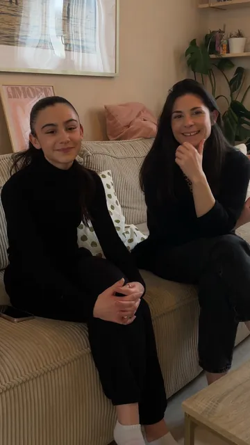 Emma, élève de chant, et sa maman sourient côte à côte sur leur canapé